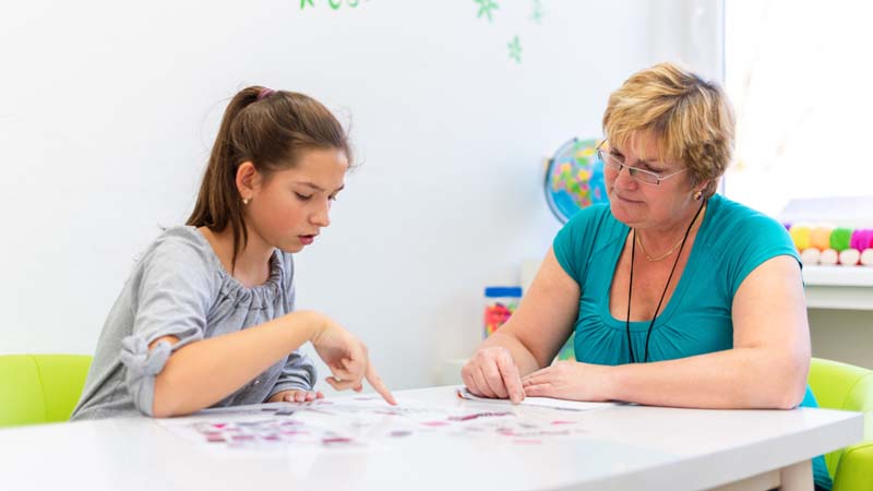 child with teacher in classroom