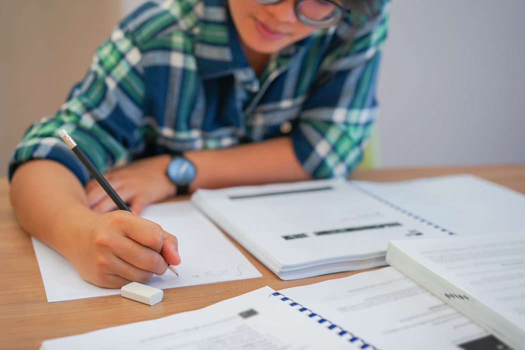 Student writing at desk